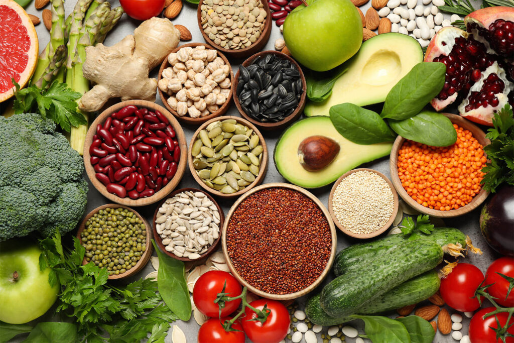 Different vegetables, seeds and fruits on grey table, flat lay. Healthy diet